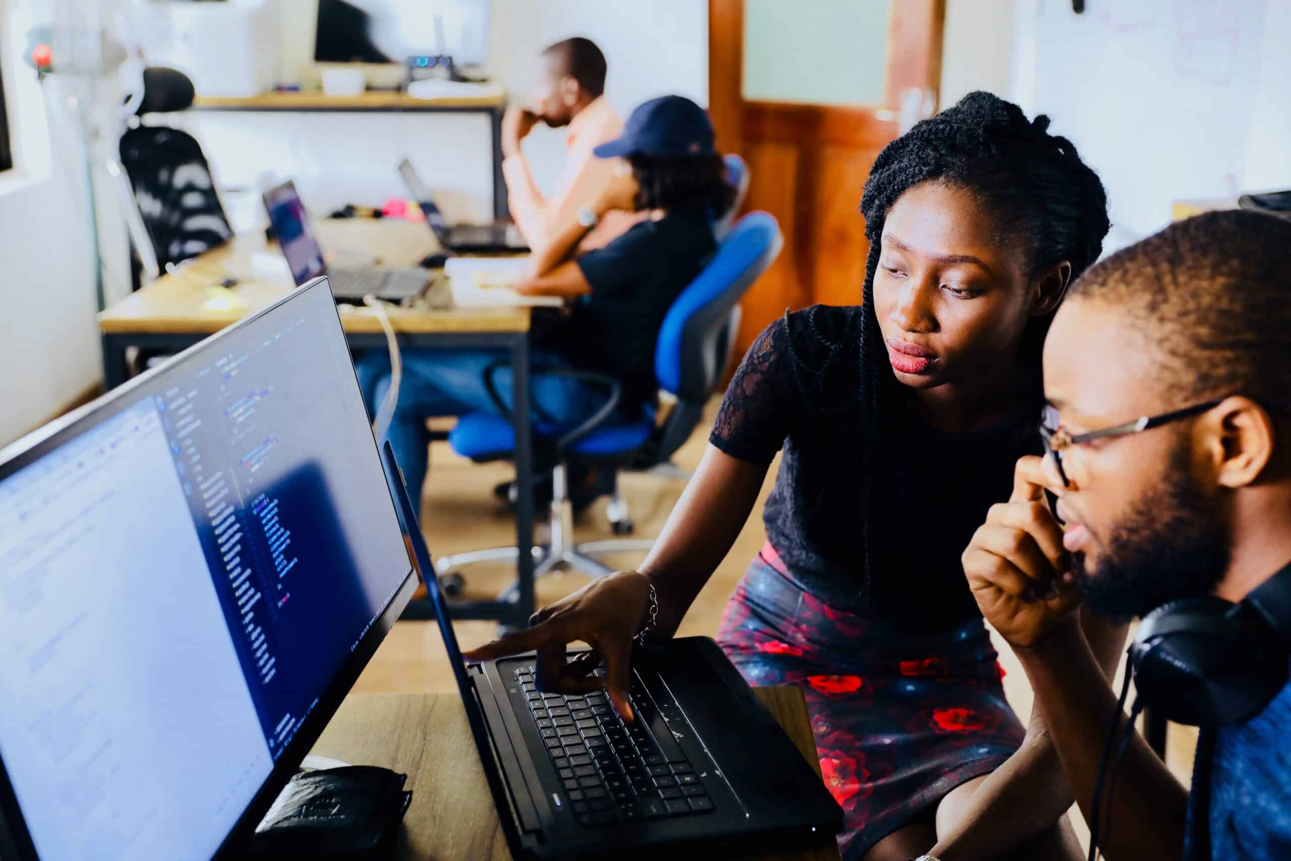 Photo by Desola Lanre Ologun, Unspalsh. Image of corporate teammates looking at screen together