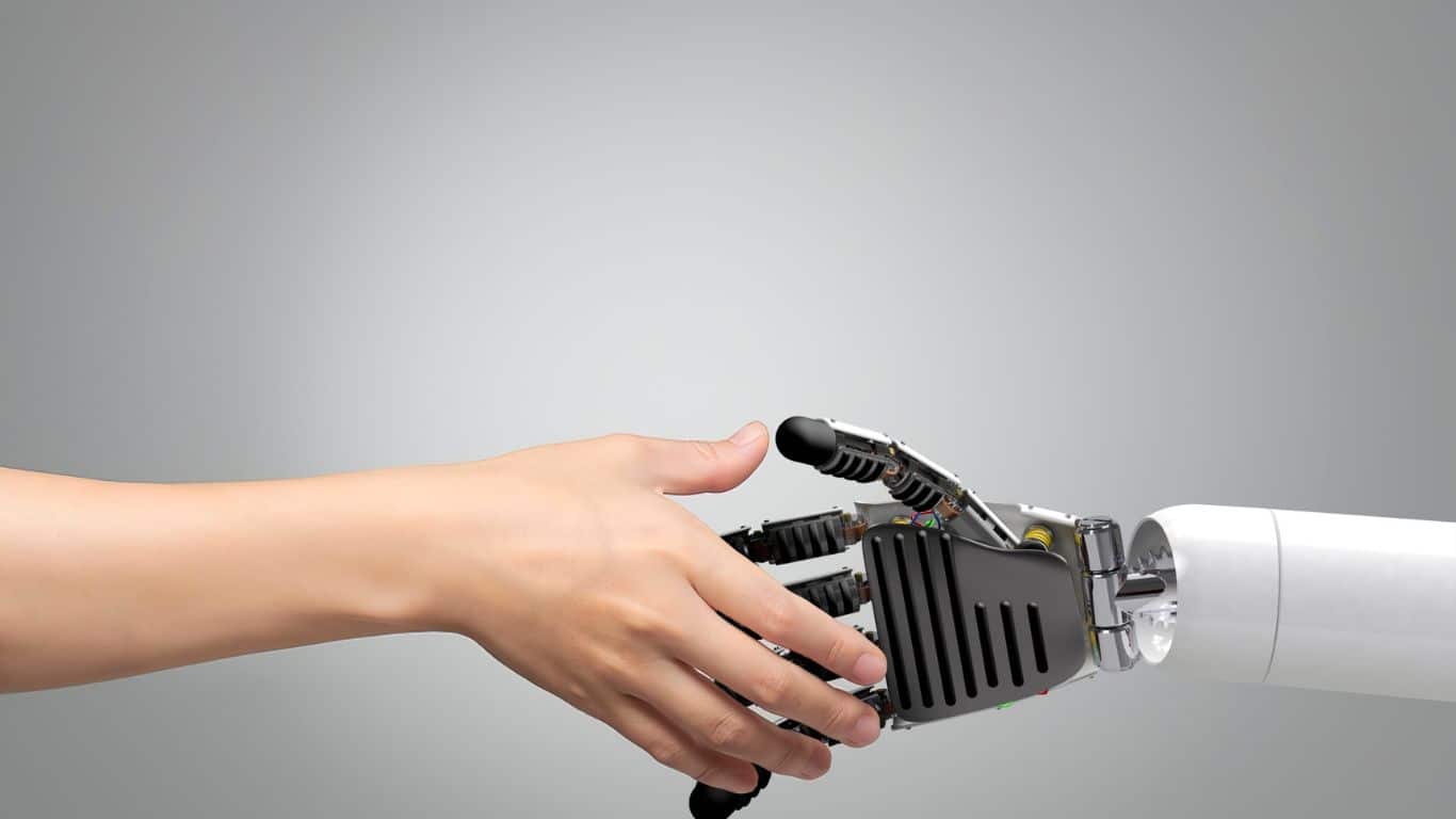 Human hand shaking AI hand